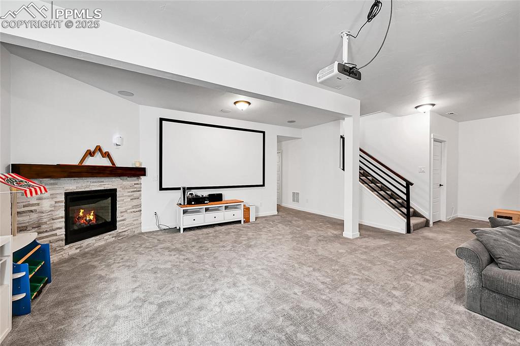 Image 23 of 29: Cinema featuring light carpet and a fireplace