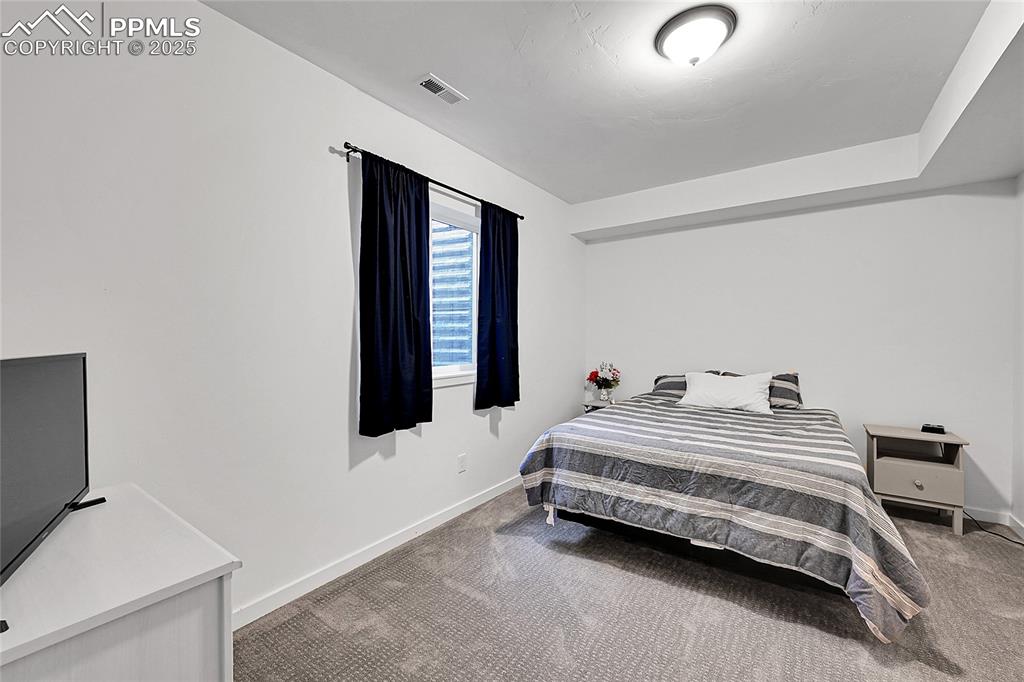 Image 25 of 29: Carpeted bedroom with baseboards