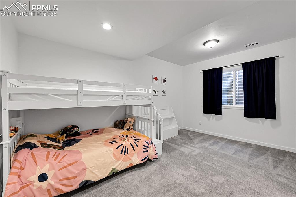Image 28 of 29: Bedroom with light colored carpet and recessed lighting