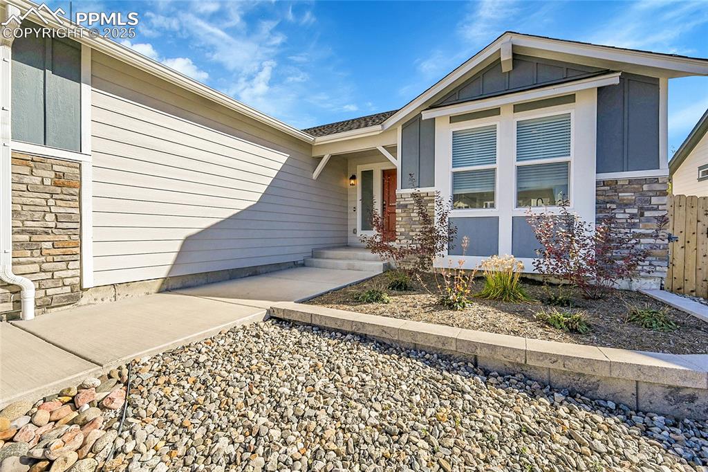 Image 3 of 29: Property entrance featuring stone siding and board and batten siding