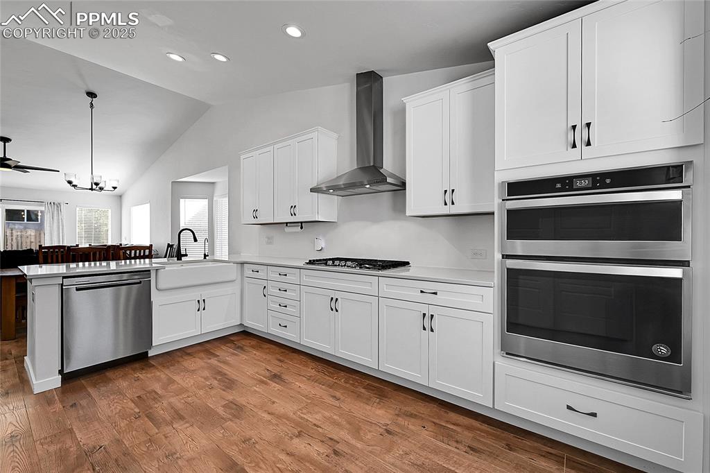 Image 7 of 29: Kitchen featuring appliances with stainless steel finishes, white cabinets,