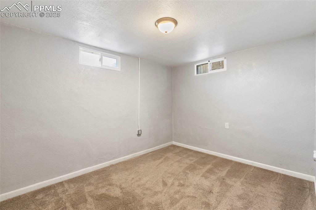 Image 12 of 25: Basement featuring healthy amount of natural light, carpet, a textured ceil