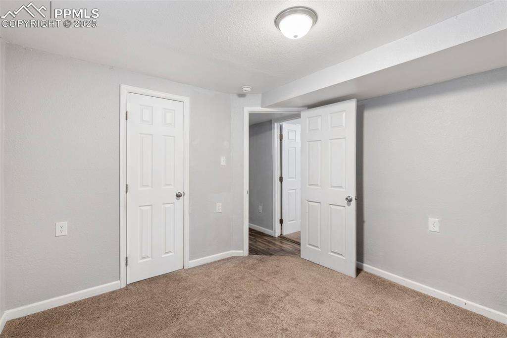 Image 14 of 25: Below grade area with carpet and a textured ceiling