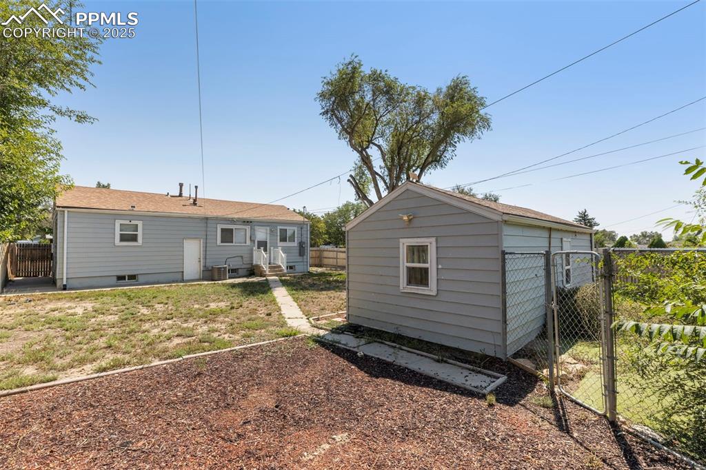 Image 21 of 25: View of outbuilding featuring a gate and entry steps