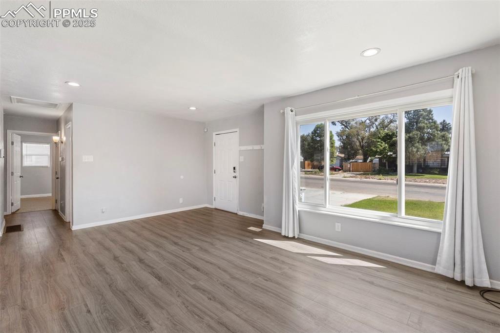 Image 5 of 25: Unfurnished living room featuring light wood/laminate-style floors and rece