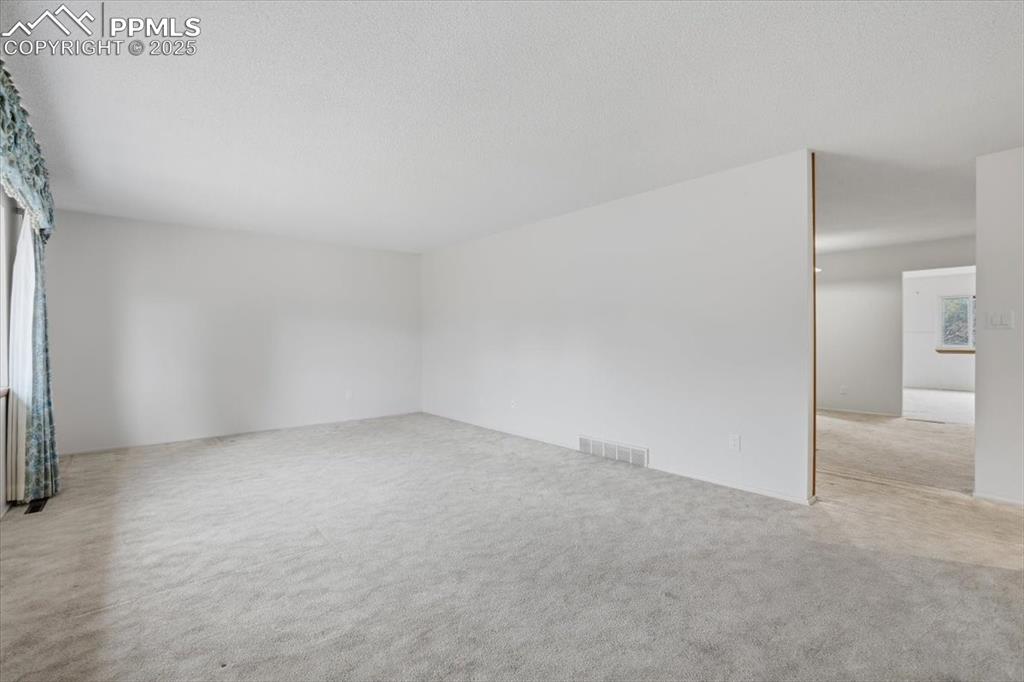 Image 19 of 50: Empty room with light carpet and a textured ceiling