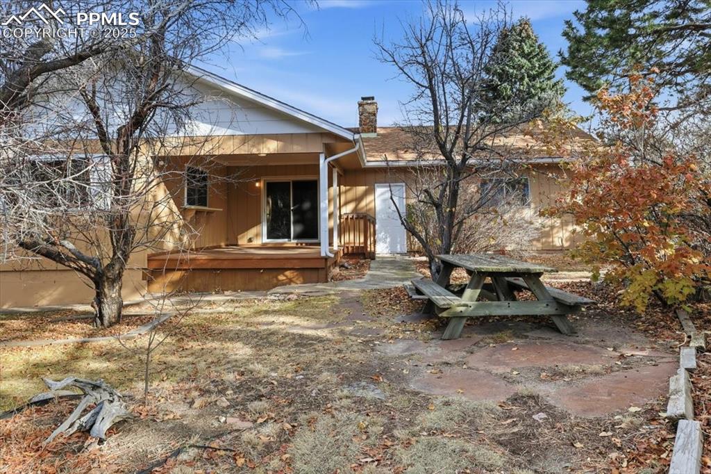 Image 3 of 50: Back of property featuring a chimney and a wooden deck