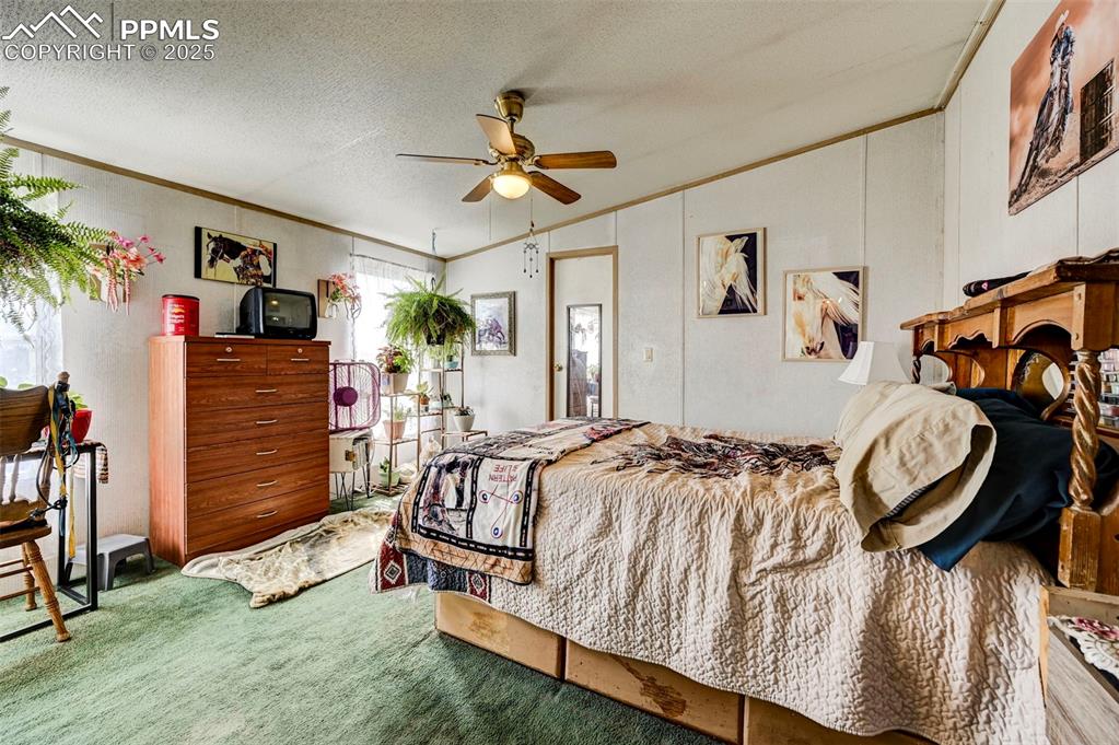 Image 11 of 44: Carpeted bedroom featuring ornamental molding, lofted ceiling, a textured c