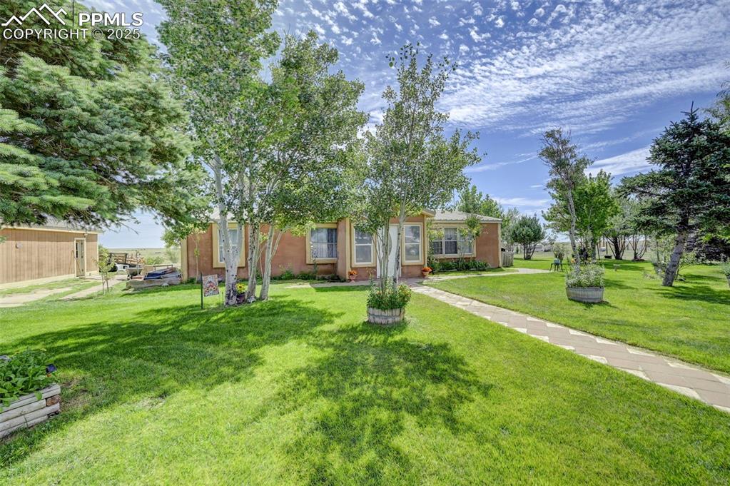 Image 3 of 44: View of front of house featuring a front lawn and stucco siding