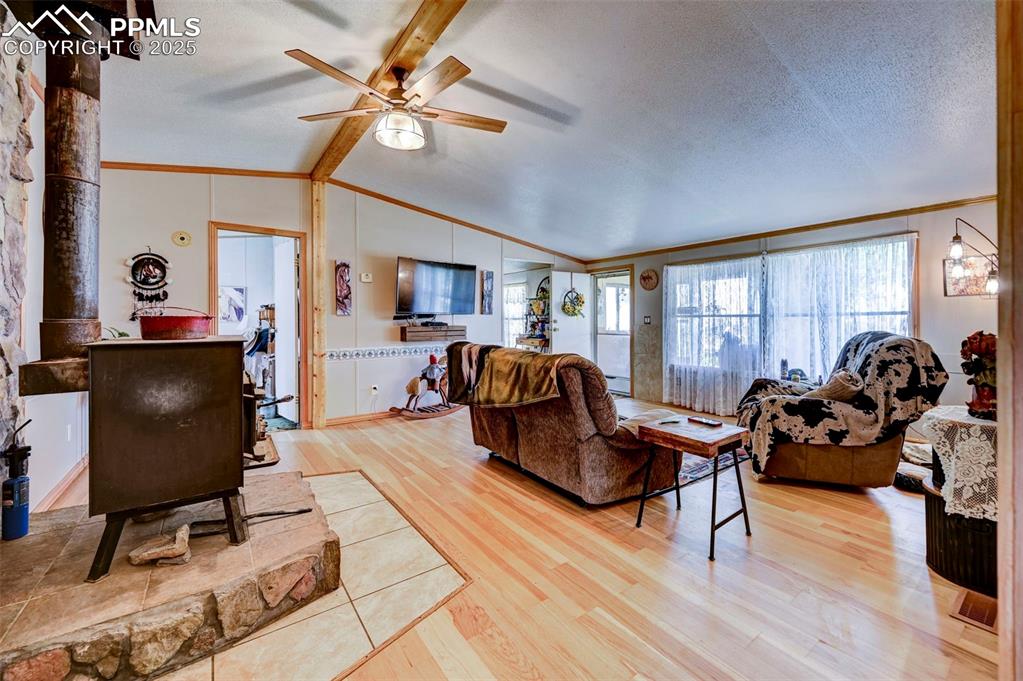 Image 8 of 44: Living room with ceiling fan, light wood-style flooring, a textured ceiling