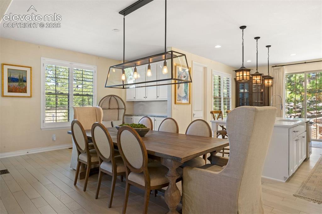 Image 11 of 49: Dining area featuring light wood-finish flooring and a contemporary linear 