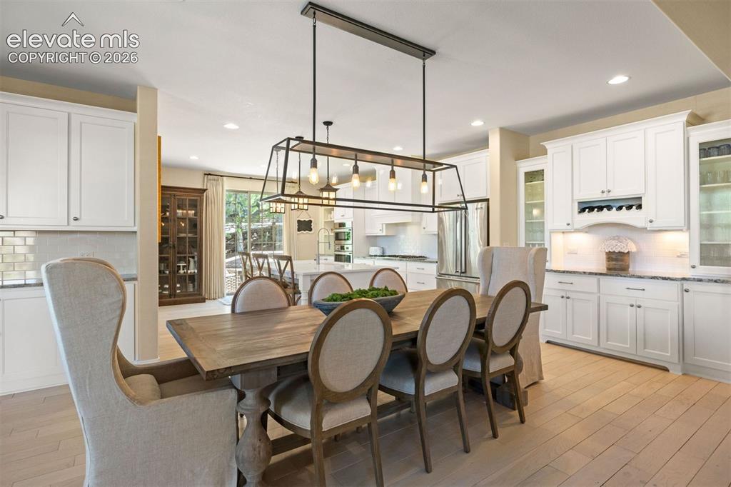 Image 12 of 49: Dining area featuring a rectangular chandelier, light-toned wood-finish flo