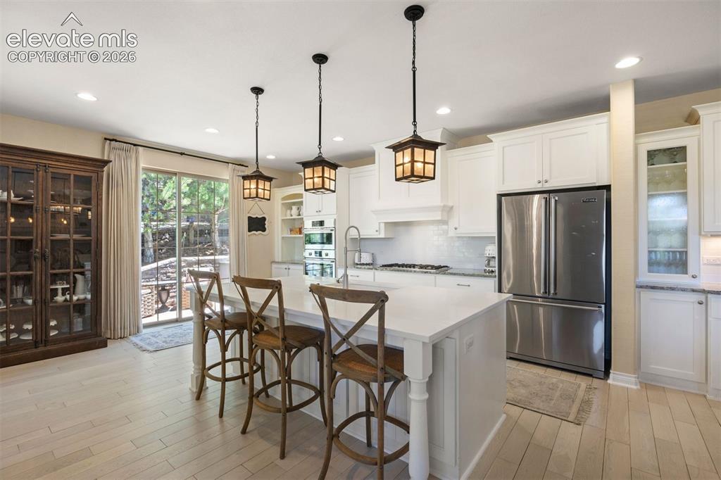 Image 14 of 49: Open-concept kitchen featuring an expansive central island with counter sea