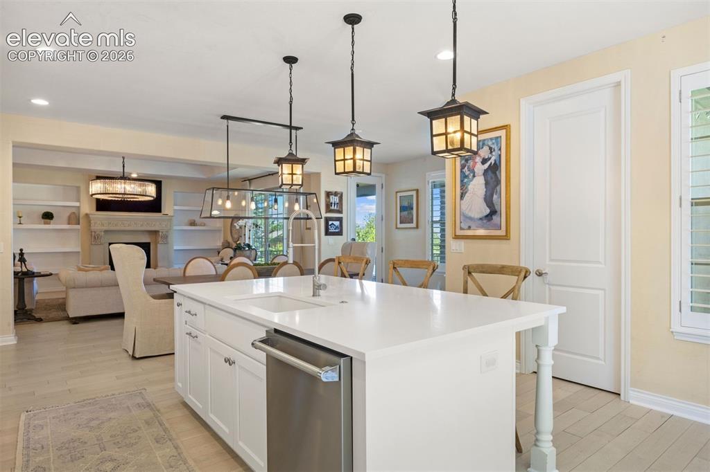 Image 15 of 49: Kitchen island with white countertop and integrated sink