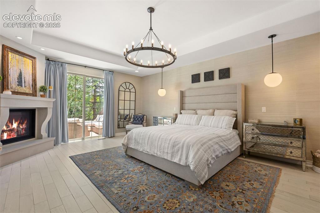 Image 20 of 49: Spacious room featuring light wood-finish flooring, a stone-surround firepl