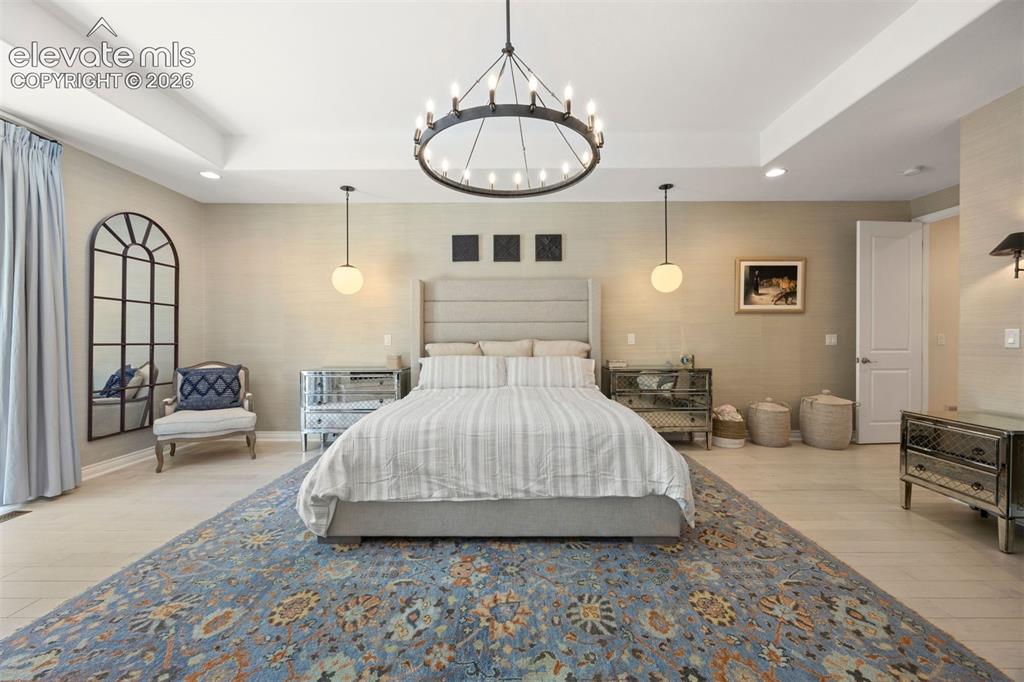 Image 23 of 49: Spacious room featuring light wood-finish flooring, a tray ceiling, and an 