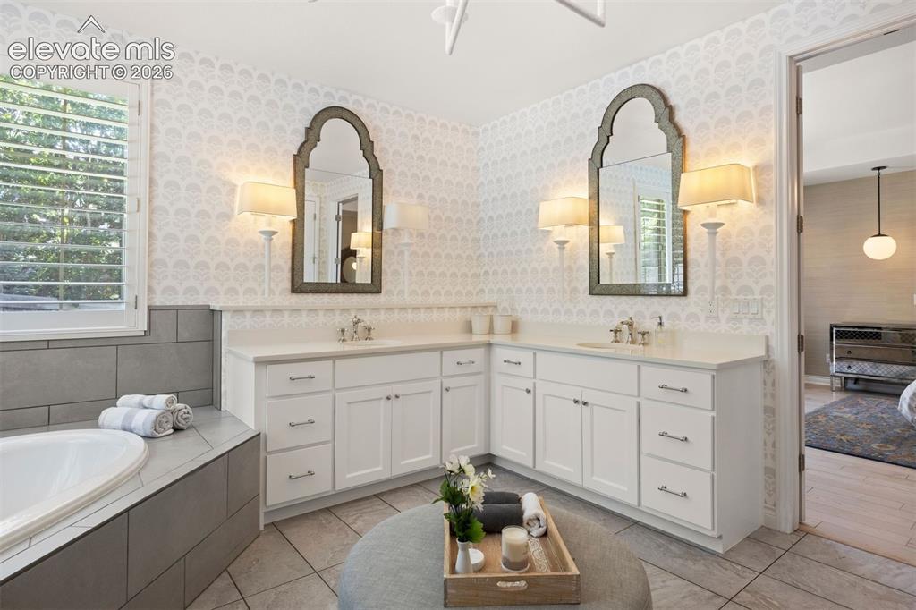 Image 25 of 49: Dual vanity with white cabinetry and countertops