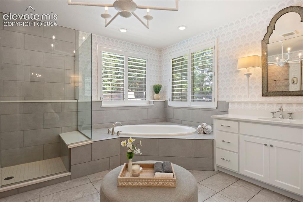 Image 26 of 49: Spacious bathroom featuring a built-in soaking tub, a walk-in shower with a