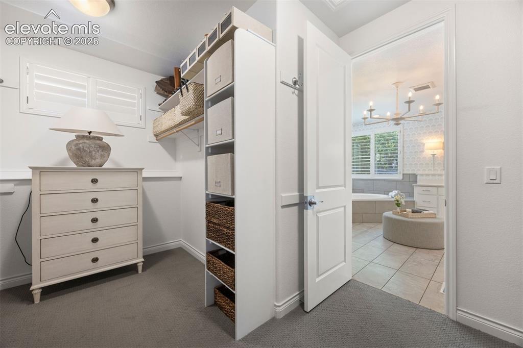 Image 29 of 49: Carpeted room with a full-view door opening into a tiled bathroom