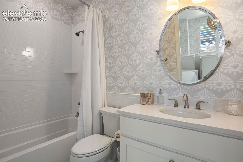 Image 31 of 49: Bathroom featuring a white subway-tiled tub and shower combination with an 