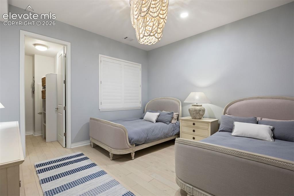 Image 36 of 49: Light-hued wood-finish flooring provides a bright base for this room, featu