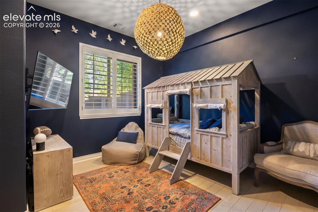 Image 38 of 49: Bedroom featuring a built-in house-frame bed, light wood-finish flooring, a