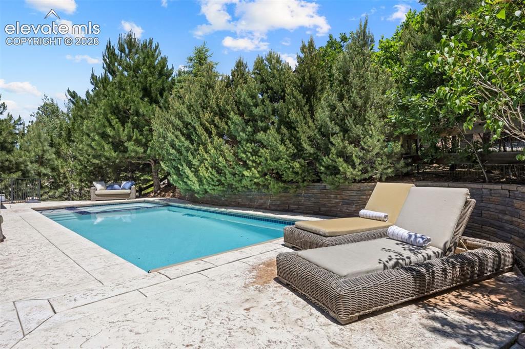 Image 45 of 49: Rectangular swimming pool with a stone patio surround