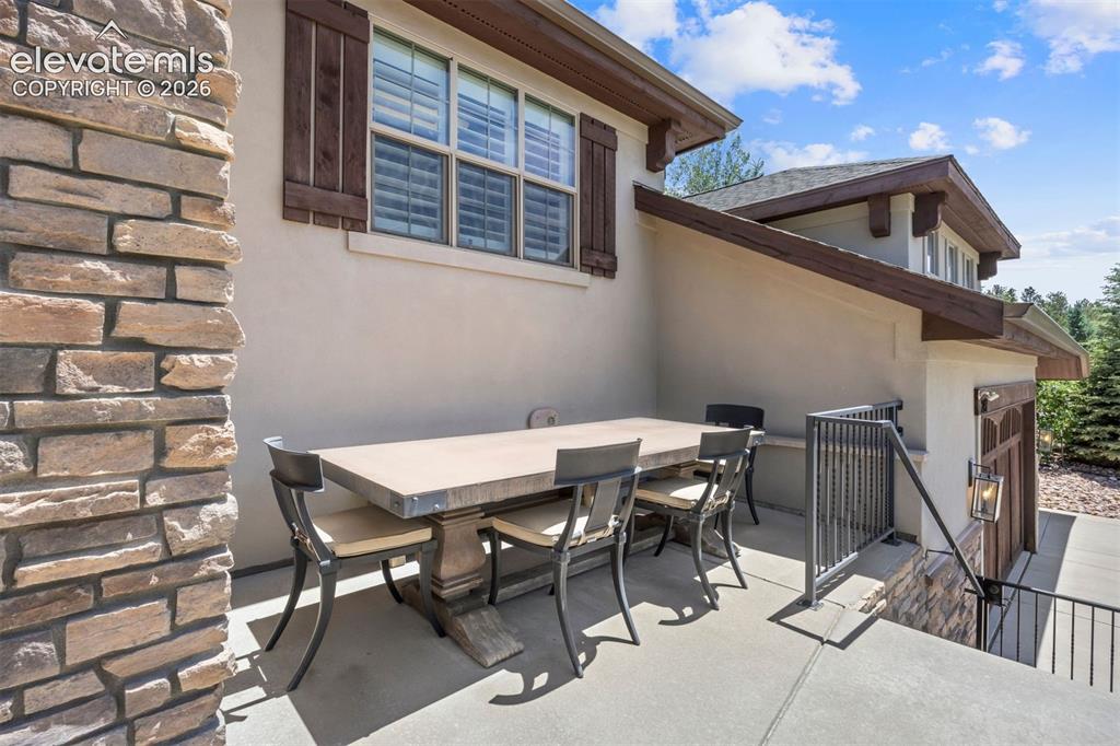 Image 47 of 49: Spacious outdoor patio with a concrete surface, stone veneer accent wall, a