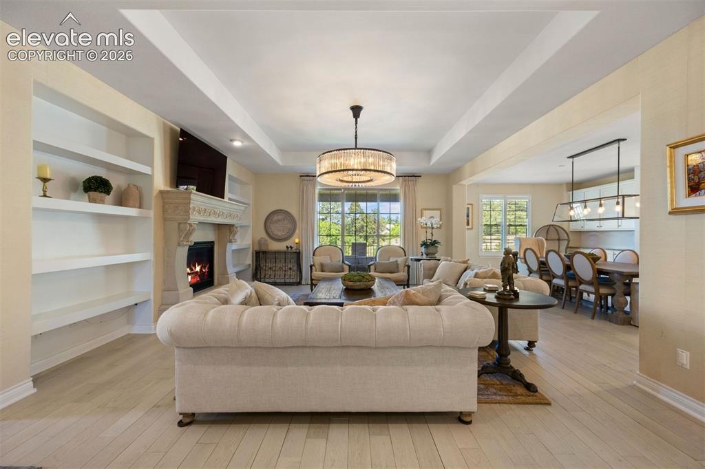 Image 9 of 49: Spacious living area featuring light wood-finish flooring, a decorative fir