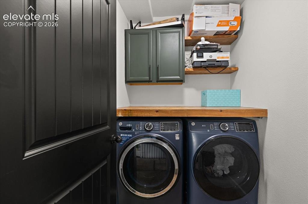 Image 12 of 39: Dark paneled door, wood-finish countertop, built-in cabinetry, and floating