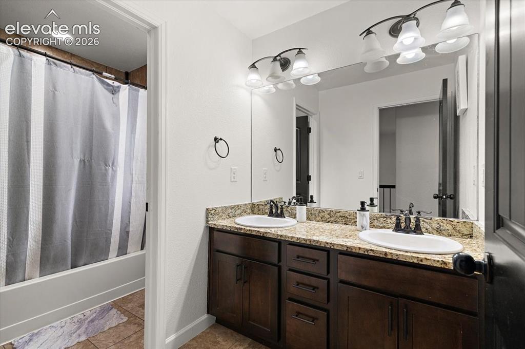 Image 19 of 39: Dual vanity with granite-style countertop and undermount sinks
