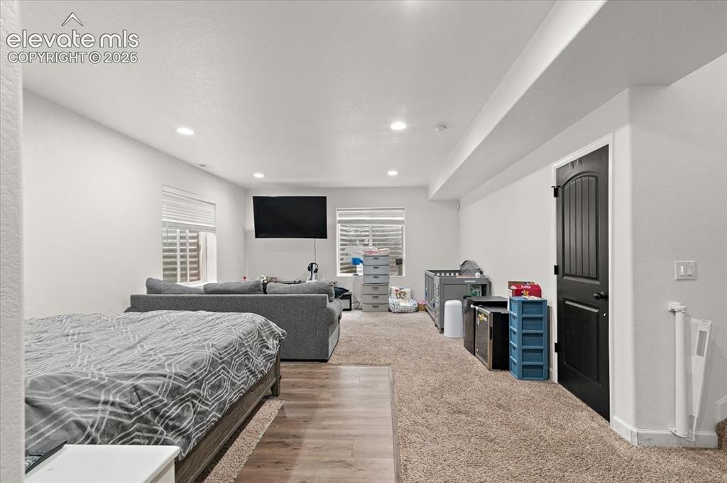 Image 23 of 39: Recessed lighting, wood-finish flooring, carpeted area, white walls, and a 