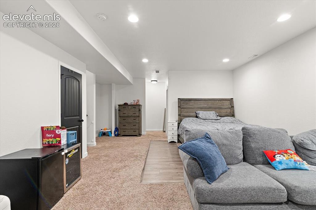 Image 24 of 39: Recessed lighting illuminates this versatile space featuring light-toned ca