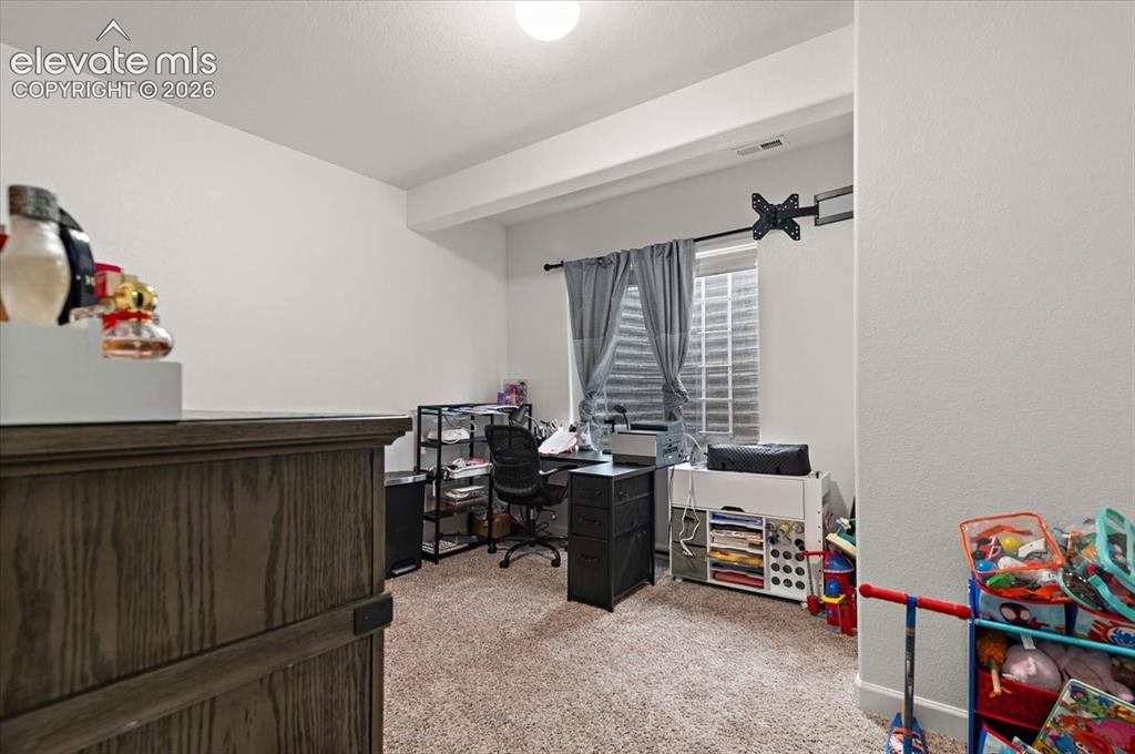 Image 25 of 39: Carpeted room with a ceiling light fixture and a window with horizontal bli