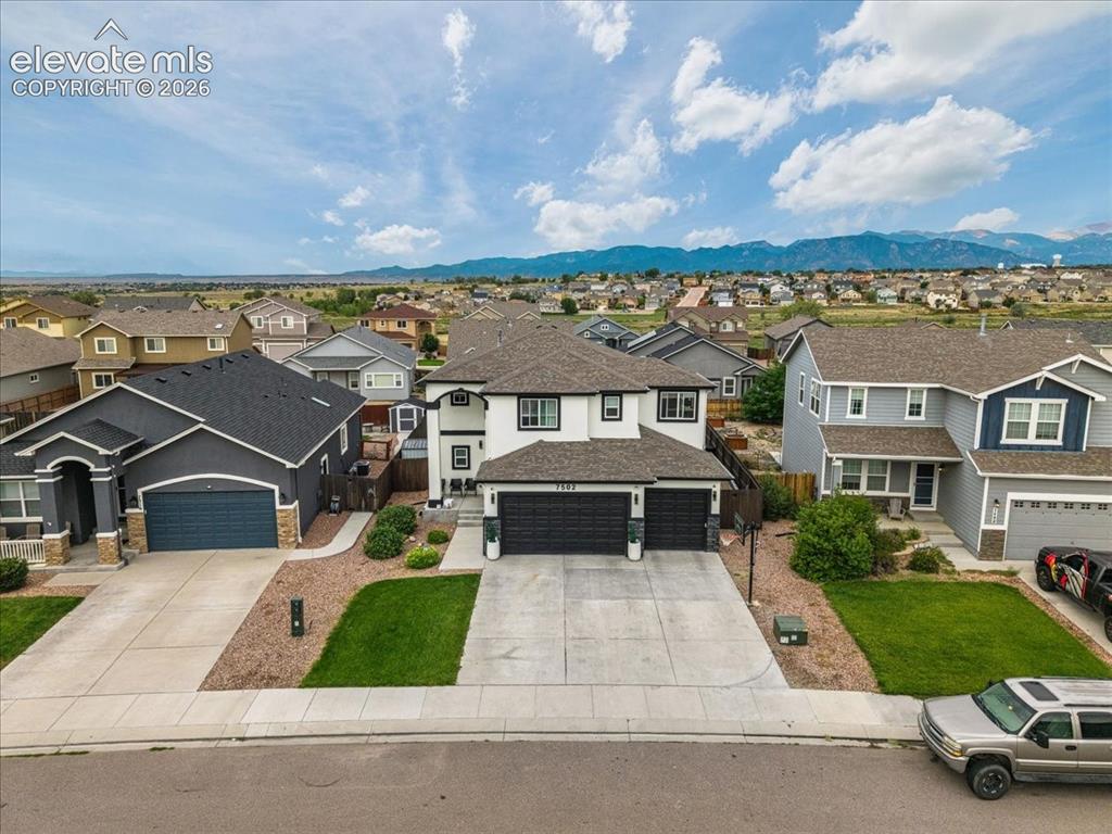 Image 29 of 39: Two-story residence with a white and black exterior, featuring a two-car ga