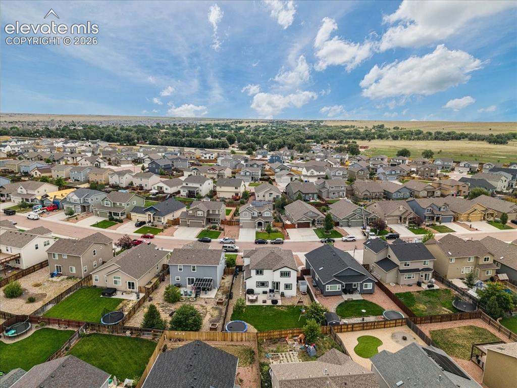 Image 35 of 39: Residential neighborhood with diverse home exteriors, manicured lawns, and
