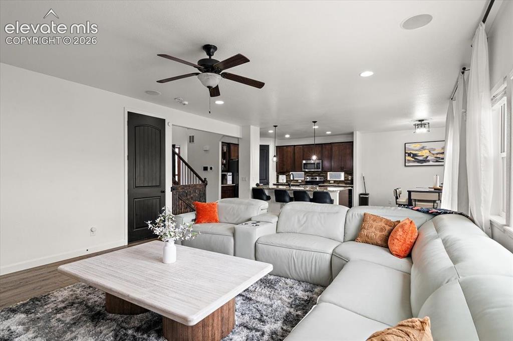 Image 9 of 39: Recessed lighting, wood-finish flooring, ceiling fan, dark wood cabinetry, 