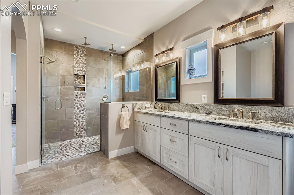 Image 13 of 42: Features include 4 head walk in large stone shower and river rock flooring.