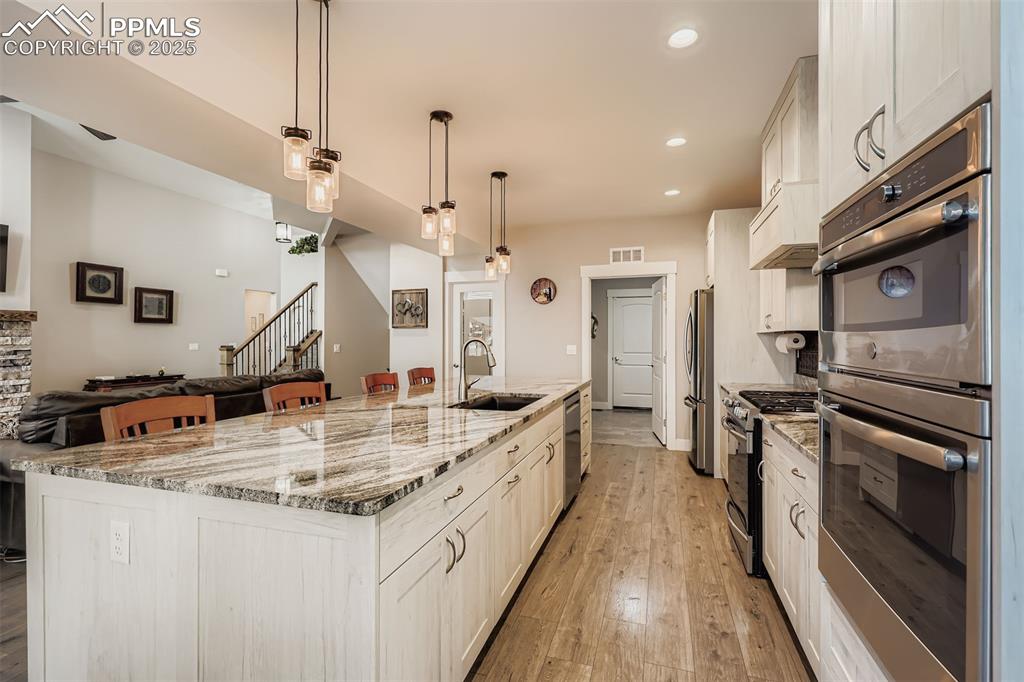 Image 8 of 42: This cooks delight kitchen includes solid stone countertops and custom soft