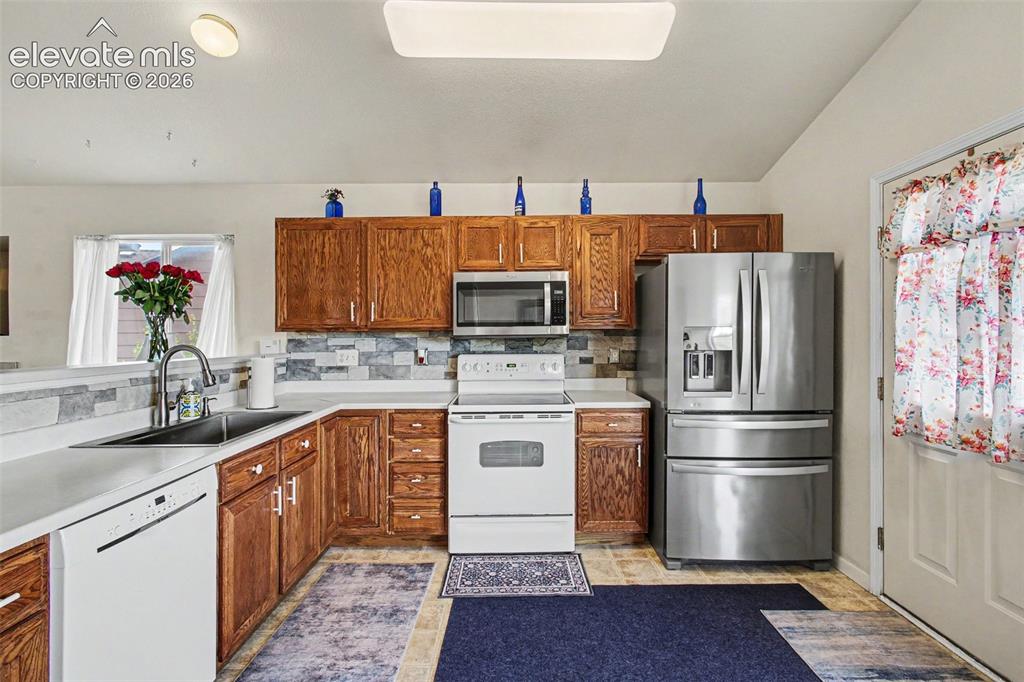 Image 11 of 33: Well-appointed kitchen featuring wood cabinetry, white countertops, and a f