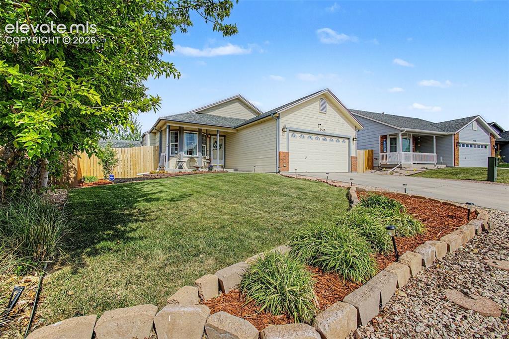 Image 2 of 33: Front exterior with an attached garage, featuring a paved driveway and a ma