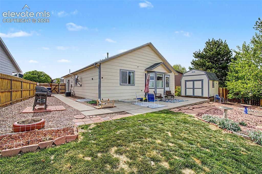 Image 27 of 33: Backyard featuring a concrete patio, wood privacy fence, and a freestanding