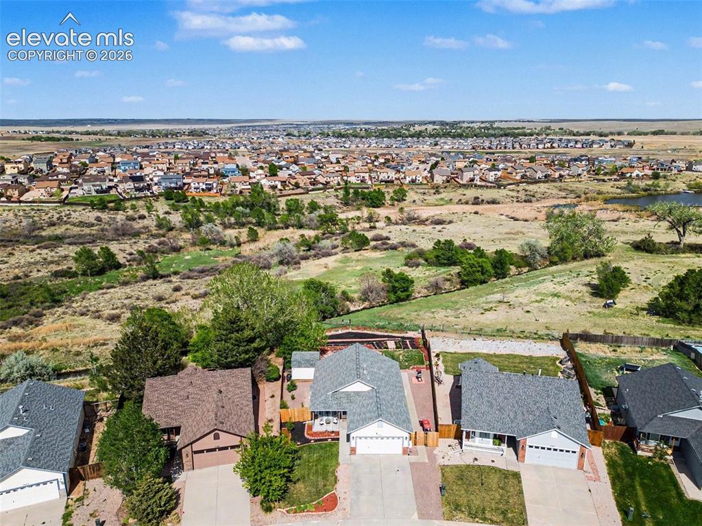 Image 32 of 33: Aerial perspective showcasing a residential neighborhood bordering open pla