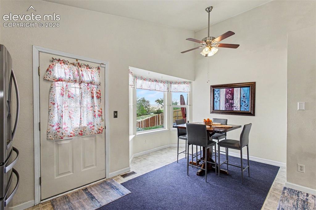 Image 6 of 33: Breakfast nook featuring a bay window, vaulted ceiling, and ceiling fan wit