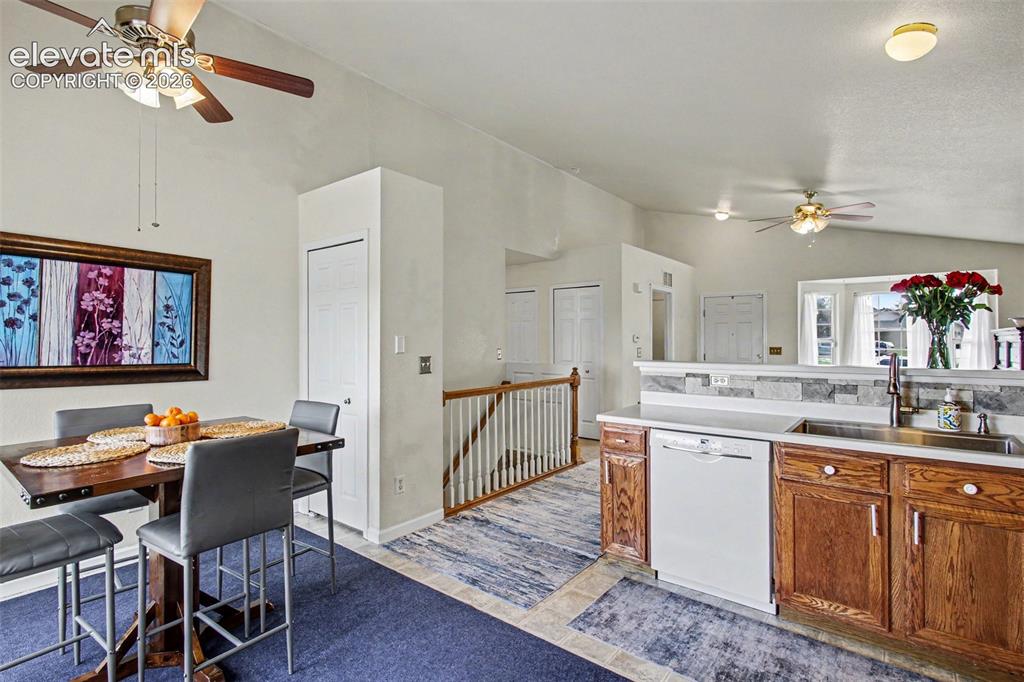 Image 7 of 33: Open-concept kitchen and dining area featuring vaulted ceilings, a built-in