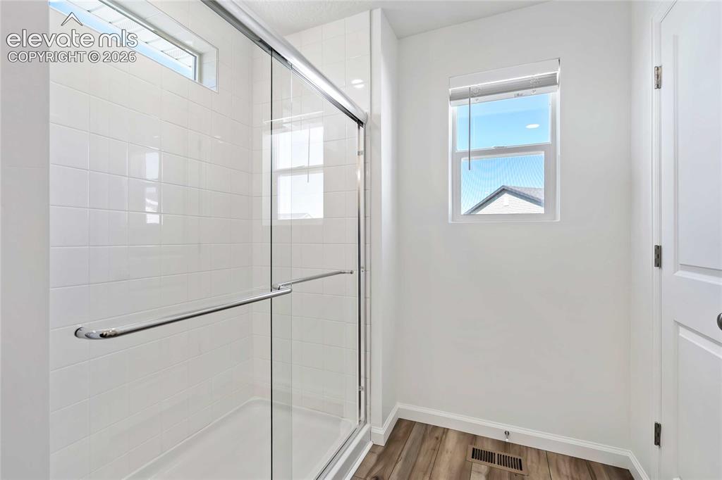 Image 13 of 25: Shower with clear glass enclosure, white subway tile surround, and chrome h