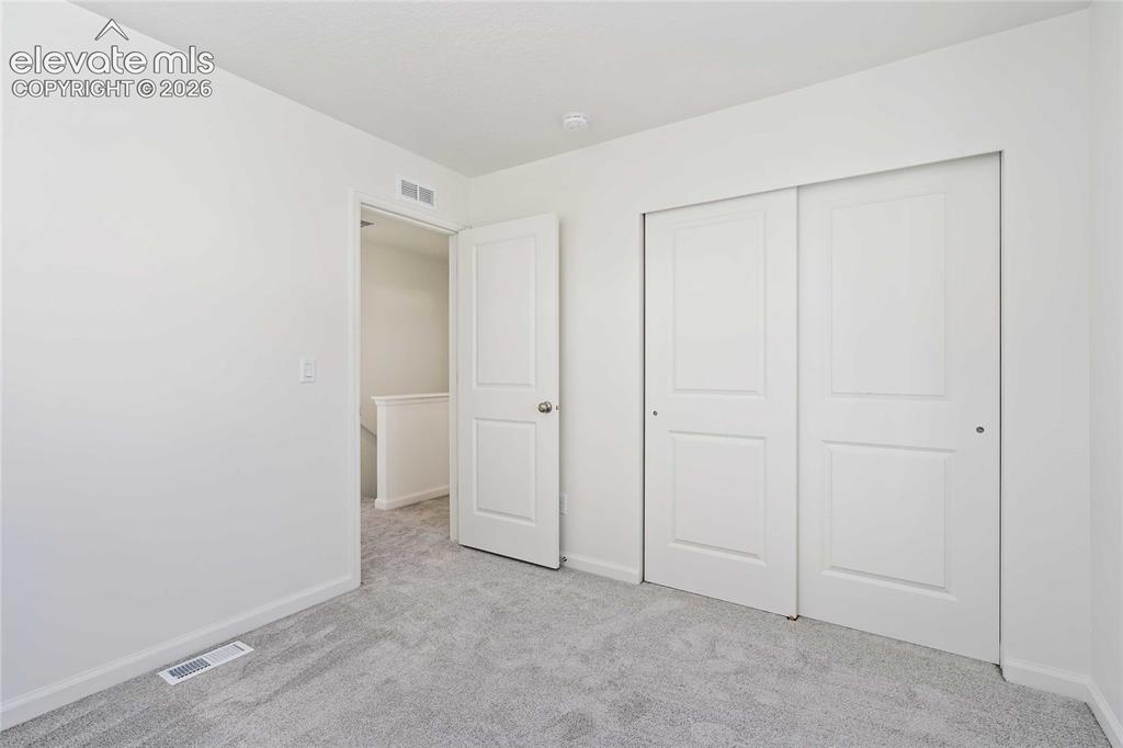 Image 22 of 25: Plush grey carpeting, white interior walls, and contemporary sliding closet