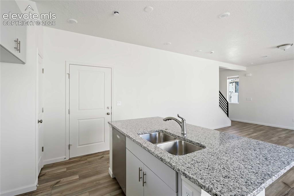 Image 6 of 25: Kitchen island with a dual basin sink and a high-arc faucet, granite counte