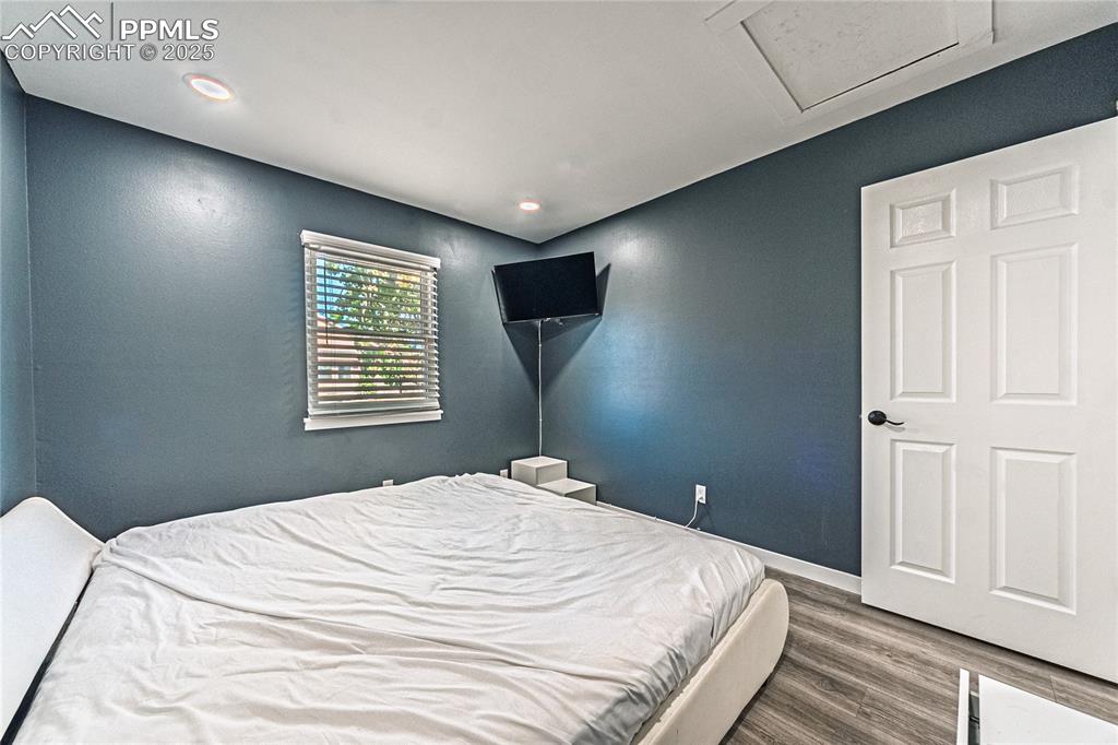 Image 16 of 46: Bedroom with wood finished floors, attic access, and recessed lighting