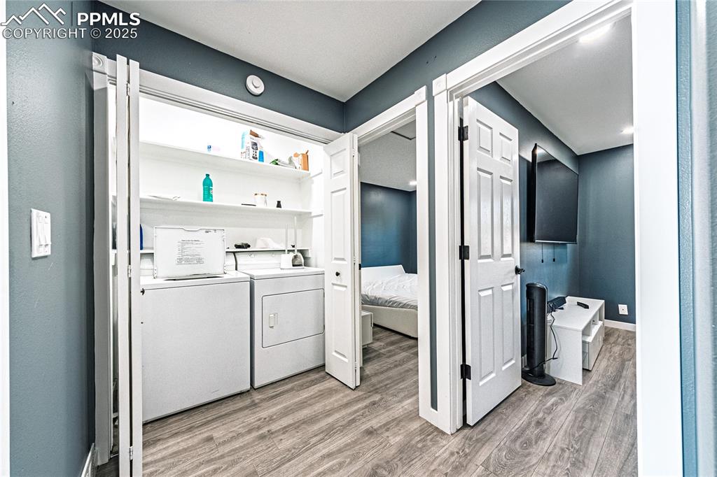 Image 19 of 46: Washroom with light wood-style flooring and separate washer and dryer